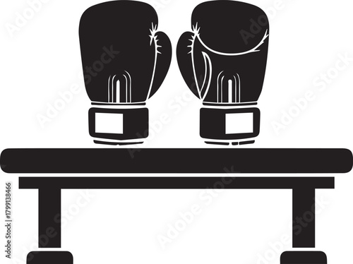 Pair of black boxing gloves resting on a simple wooden bench ready for training