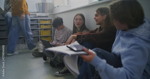 Students Sit Together on Floor Around Laptop, Sharing Ideas and Writing Notes During Collaborative Study Session. Concept Peer Learning, Open Dialogue, and Flexible Modern Classroom Environment.
