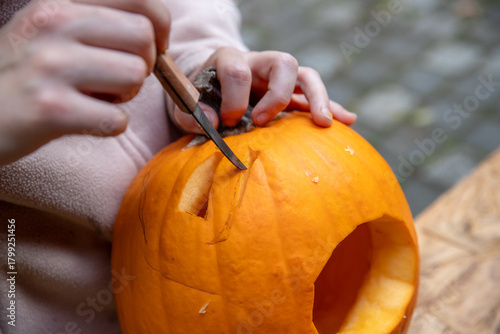 Ein Gesicht in einen Kürbis zu Halloween schnitzen