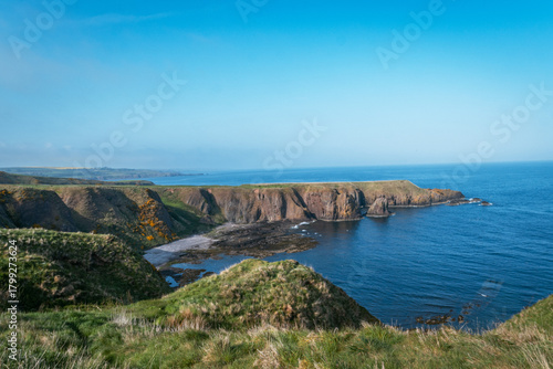 Scenic green coastal cliffs and rocky bay