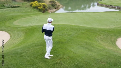 Golfer swings club in beautiful green landscape during afternoon round
