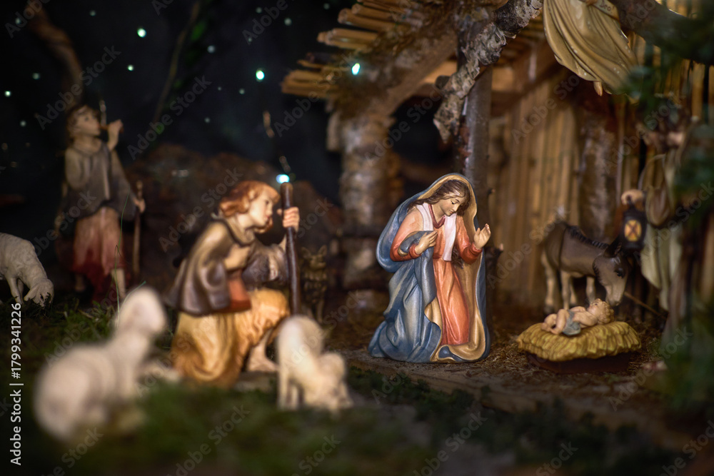 Fototapeta premium A Christmas manger scene with beautifully carved figures, including baby Jesus, Mary, Joseph, shepherds and animals. Emotions visible on the characters' faces.