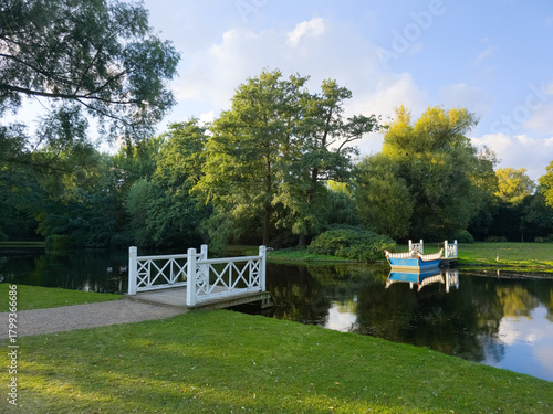 Frederiksberg, Denmark - September 8, 2025: A wooden boat and two jetties in Frederiksberg Gardens.