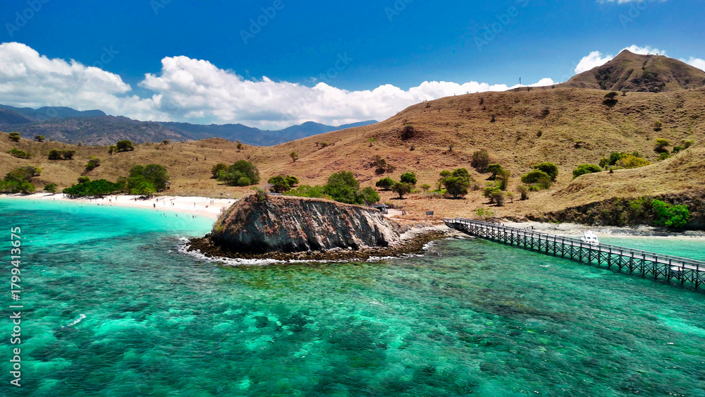 Obraz premium Scenic overhead aerial landscape of Komodo Island’s Pink Beach surrounded by lush green hills