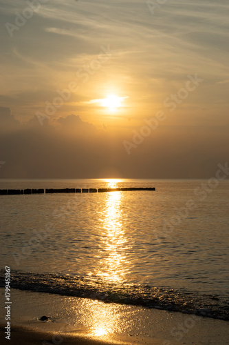 Złoty zachód słońca nad spokojnym morzem Bałtyckim