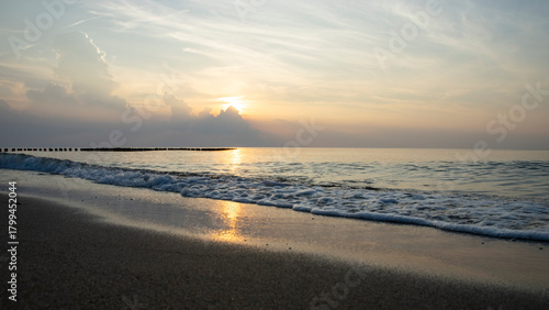Spokojne wybrzeże morza Bałtyckiego o zachodzie słońca
