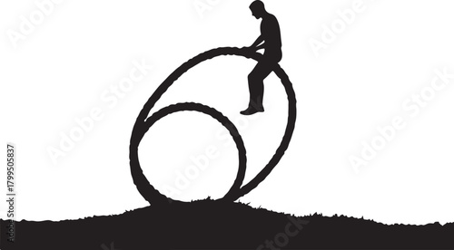 Silhouette man on large rope circle on grassy ground