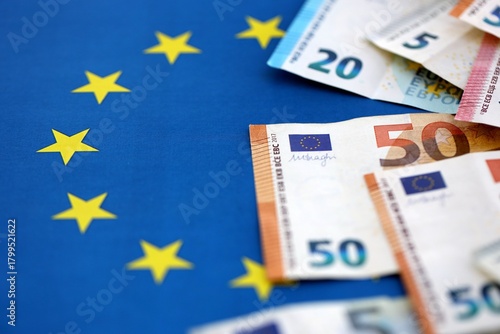 Many euro money bills banknotes on flag of European Union. Concept of business and finances in Europe