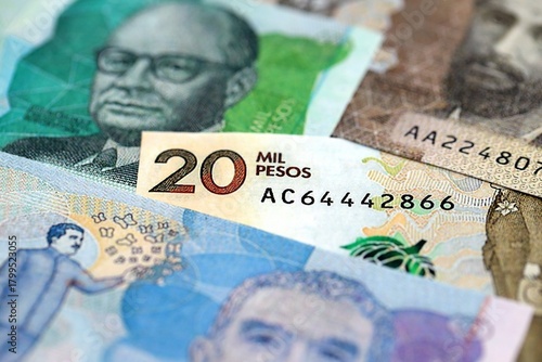 Colombian pesos money bills banknotes lies in big pile on table close up. Concept of finances and business in Colombia