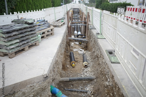 Open Trench Construction Site with Pipes and Barriers