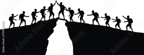 Silhouetted hikers crossing a chasm on a narrow bridge high five climbing mountain