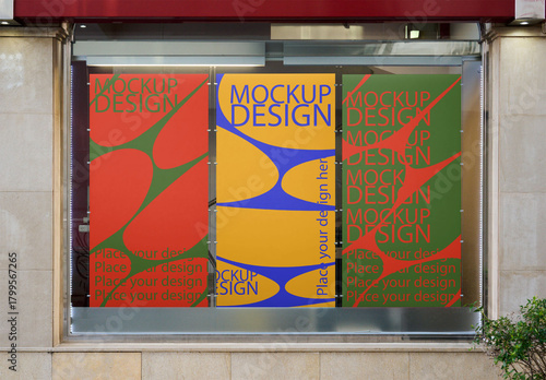 Three vertical AD posters in store window