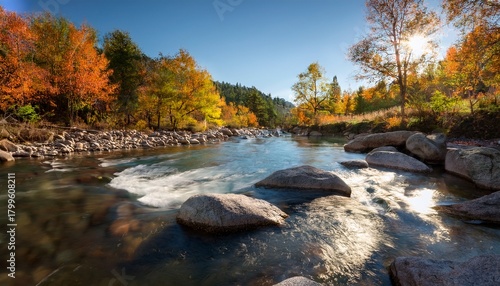 Flowing River Creates A Serene Landscape With Rocks And Trees During A Sunny Autumn Afternoon In The Wilderness