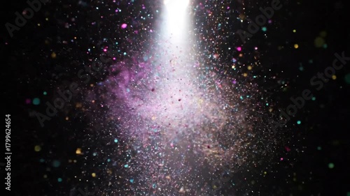 A bright light shining down on a cloud of colorful particles, creating a beautiful effect.