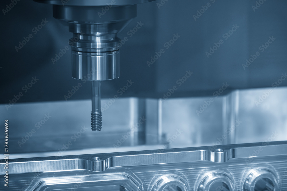 Fototapeta premium The tapping process on CNC milling machine with tapping tools.
