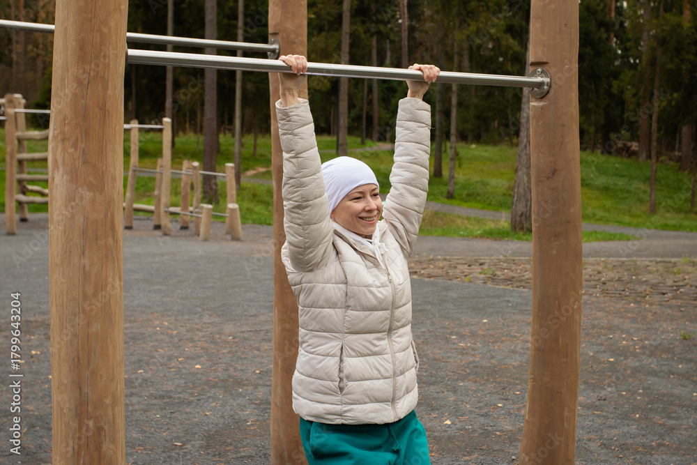 Fototapeta premium Cancer survivor performing warm-up routine outdoors, concept of health rehabilitation, active recovery, and emotional resilience.