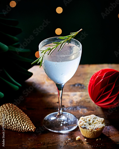 Festive Winter Cocktail with Rosemary Garnish on Rustic Table with Mice Pie