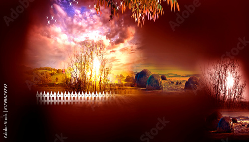 Idyllic rural landscape scene with a vibrant sunset illuminating a picturesque hayfield and fence