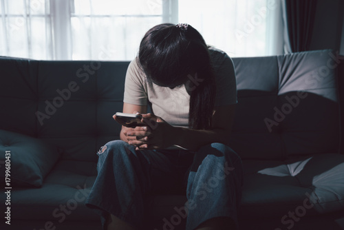 Papier peint Sorrowful woman sat alone, overwhelmed by emotion, her sad and unhappy expression revealing deep despair, stress and distress left feeling depressed