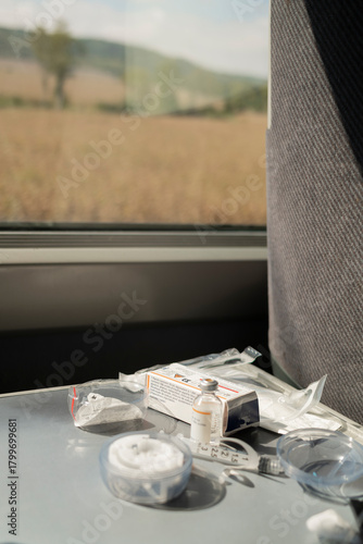 Diabetes insulin supplies on train table: vial, syringes and infusion set components