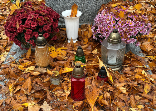 Fallen leaves and lanterns on a tombstone in the public cemetery