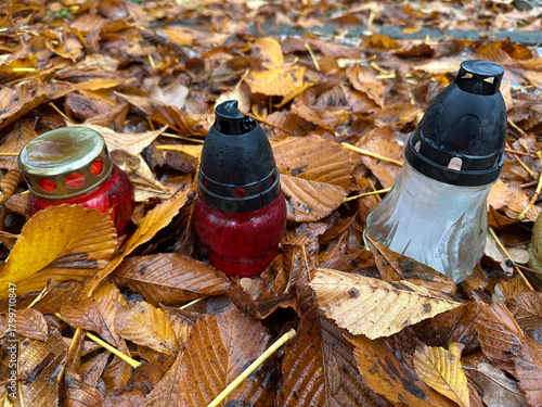 Lantern and fallen leaves on a tombstone in the public cemetery