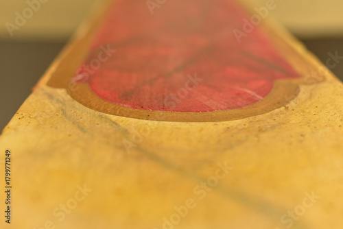 abstract close up of red and gold painted surface with textured details, artistic handcrafted object showing color contrast and organic shapes, creative composition with shallow depth of field horizon