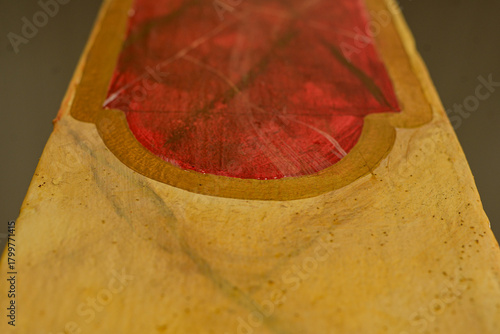 abstract close up of red and gold painted surface with textured details, artistic handcrafted object showing color contrast and organic shapes, creative composition with shallow depth of field horizon