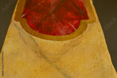 abstract close up of red and gold painted surface with textured details, artistic handcrafted object showing color contrast and organic shapes, creative composition with shallow depth of field horizon