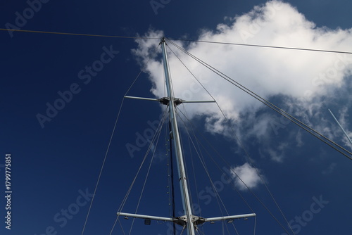 Sailboat mast and rigging against blue sky