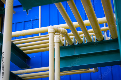 The yellow chemical pipelines inside the factory are arranged in an orderly and engineered manner, representing precision,