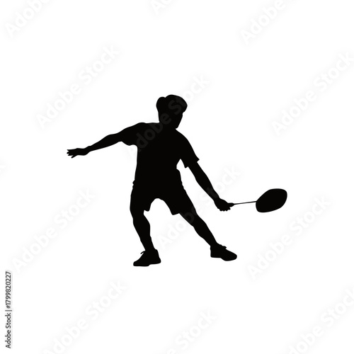 Silhouette of a young male badminton player in action hitting a shuttlecock with a racket