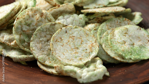 Rice wasabi chips on dark background.