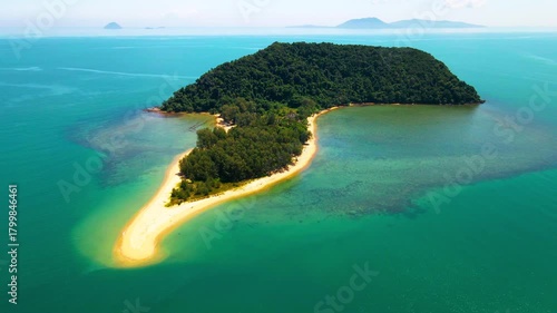 Aerial view of a small tropical island located just off the coast of Pantai Bukit Keluang in Besut, Terengganu. The island is covered in dense green forest and surrounded by vibrant turquoise waters.