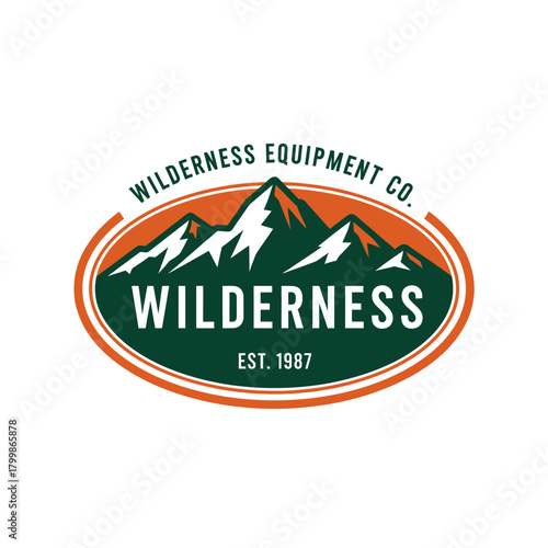 A vintage-style oval logo for Wilderness Equipment Co. featuring a mountain range with snow-capped peaks, an orange sky, and the word "WILDERNESS" prominently displayed.