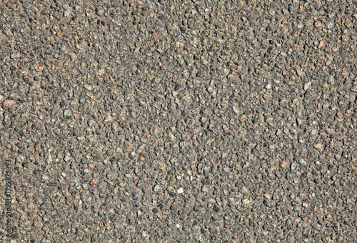Detailed view of faded asphalt surface, background. Texture of an old bitumen close-up with abstract pattern. Worn out stone backdrop. Road foundation, based on crushed stone and resin. Road backdrop