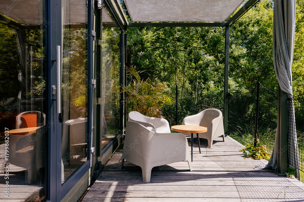 Obraz premium Cozy outdoor seating area with modern furniture surrounded by greenery