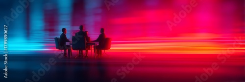 A group of silhouetted people seated around a table, set against a vibrant, blurred background of blue and red lights.