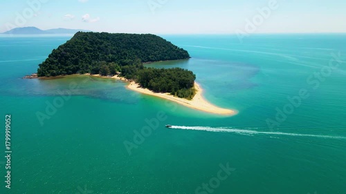Aerial view of a small tropical island located just off the coast of Pantai Bukit Keluang in Besut, Terengganu. The island is covered in dense green forest and surrounded by vibrant turquoise waters.