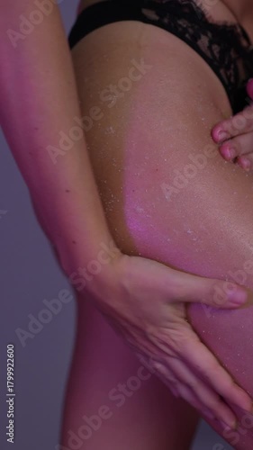 Wallpaper Mural Close-up of young woman exfoliating thigh and buttocks with body scrub massaged into smooth skin under soft pink neon light, highlighting glow, texture and self-care beauty ritual Torontodigital.ca