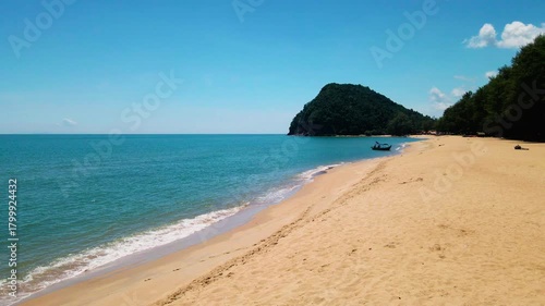 Aerial view of Pantai Bukit Keluang, Besut, Terengganu, showing turquoise waters, coastal cliffs, and clear sunny skies along the scenic shoreline.