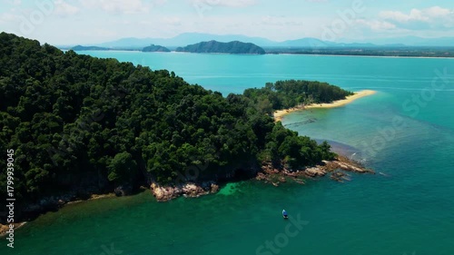 Aerial view of Pantai Bukit Keluang, Besut, Terengganu, showing turquoise waters, coastal cliffs, and clear sunny skies along the scenic shoreline.