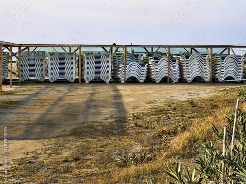 Fototapeta Naklejka Na Ścianę i Meble -  After the season, the sun loungers on the Adriatic beaches are stacked on top of each other. Montenegro