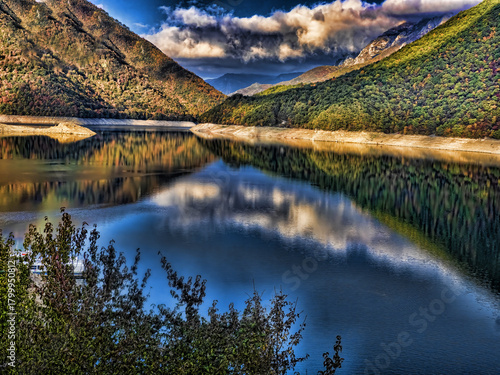 Clouds are reflected on the surface of the Piva dam lake. Montenegro