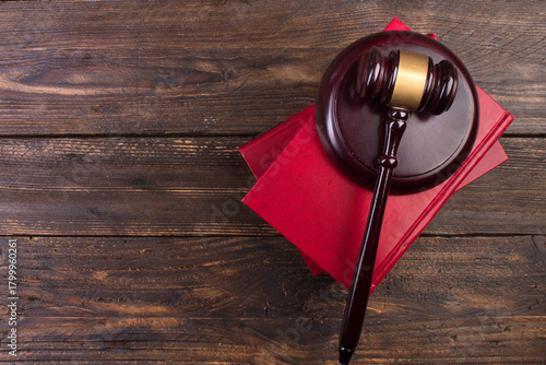 Law concept - Open law book with a wooden judges gavel on table in a courtroom or law enforcement office isolated on white background. top view.