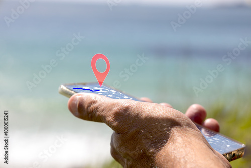 Hand holding smartphone displaying geolocation pin on screen