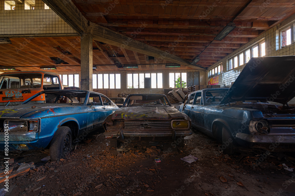 Fototapeta premium Abandoned vintage cars inside derelict Charbonnage du Renard workshop, Belgium
