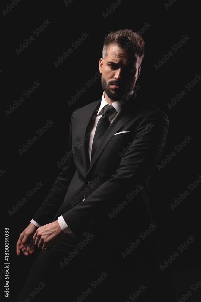 Fototapeta premium Mysterious man in suit sitting with hands in front