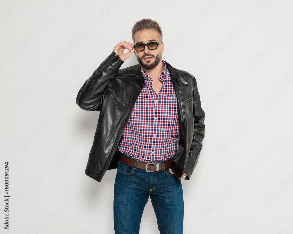 Fototapeta premium Stylish man fixing sunglasses with hand in pocket