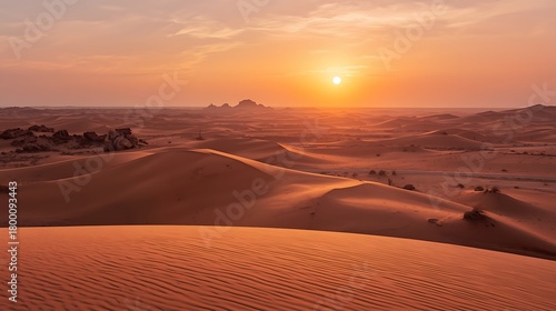 Fototapeta Naklejka Na Ścianę i Meble -  Dramatic desert sunset paints vast sand dunes in warm light